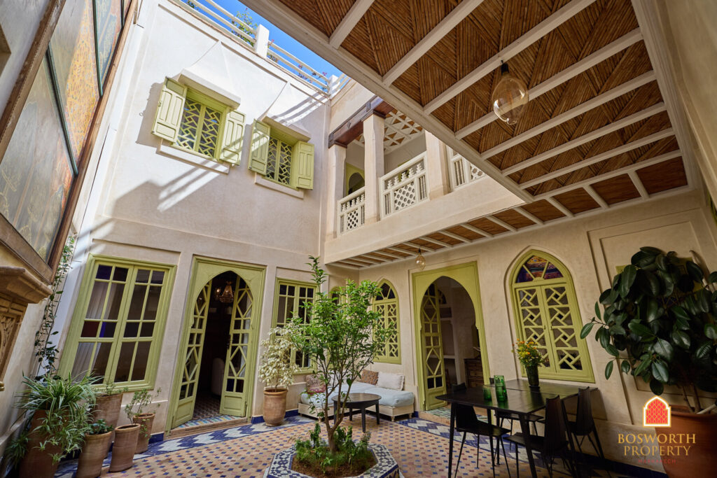 A Riad in Marrakech with green windows and a patio.